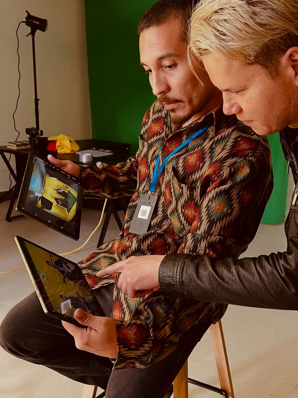 Producción en estudio: dos personas revisando tomas en tableta.